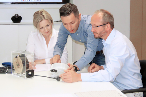 Three people talking about a cable rewinder