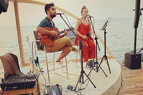 Musicians on stage with instruments and cable rewinder box