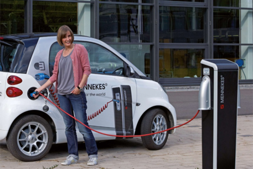 Woman charging her electric car at the charging station